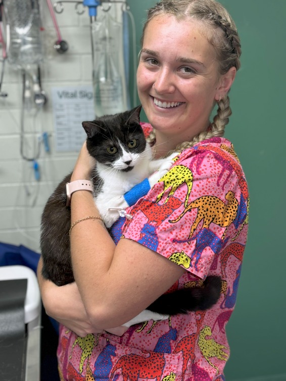 smiling blond female nurse with calico cat in arms