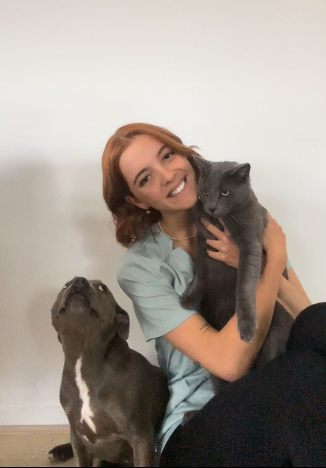 red haired female vet nurse holding black cat